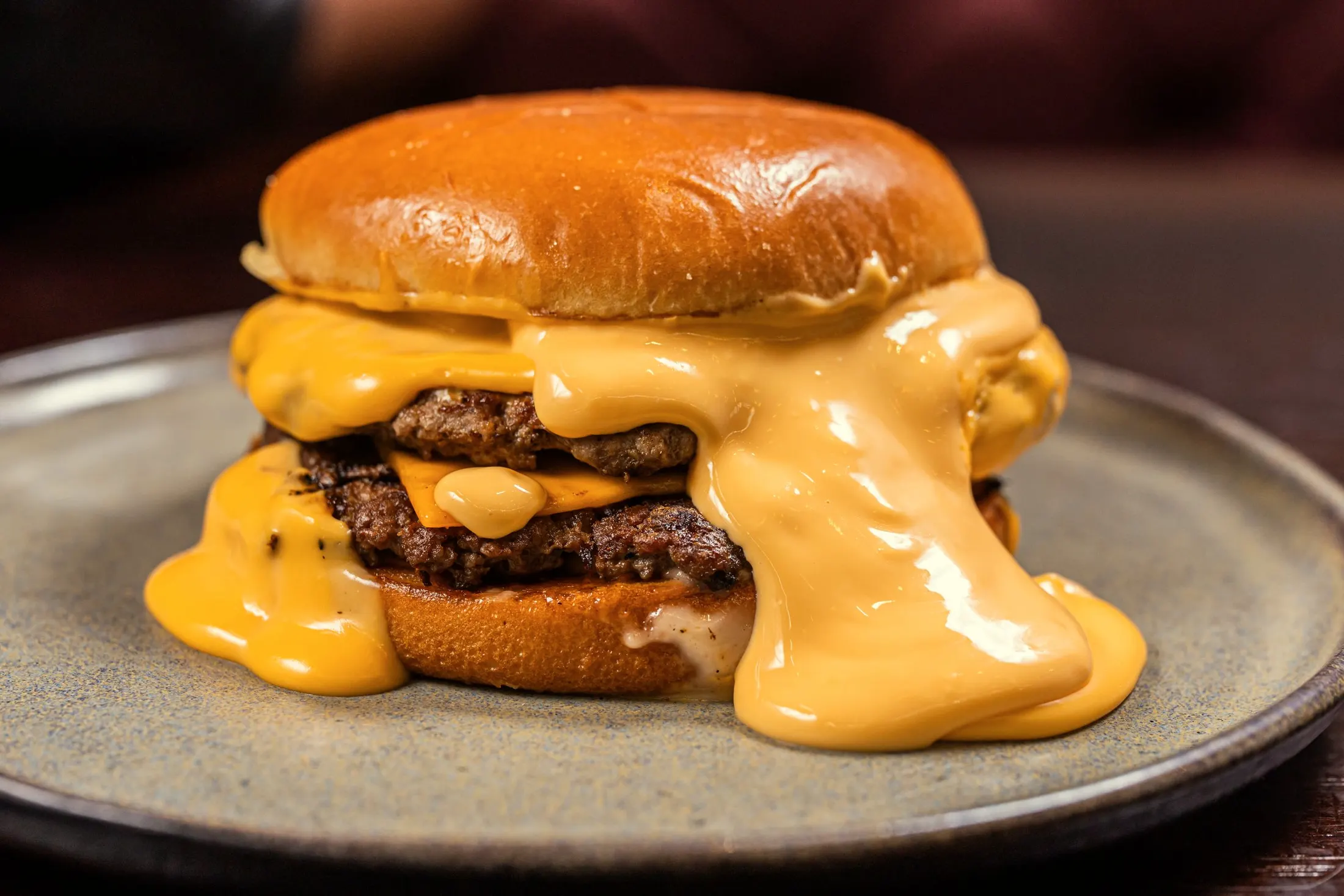 A double cheeseburger with melted cheddar running down the patties
