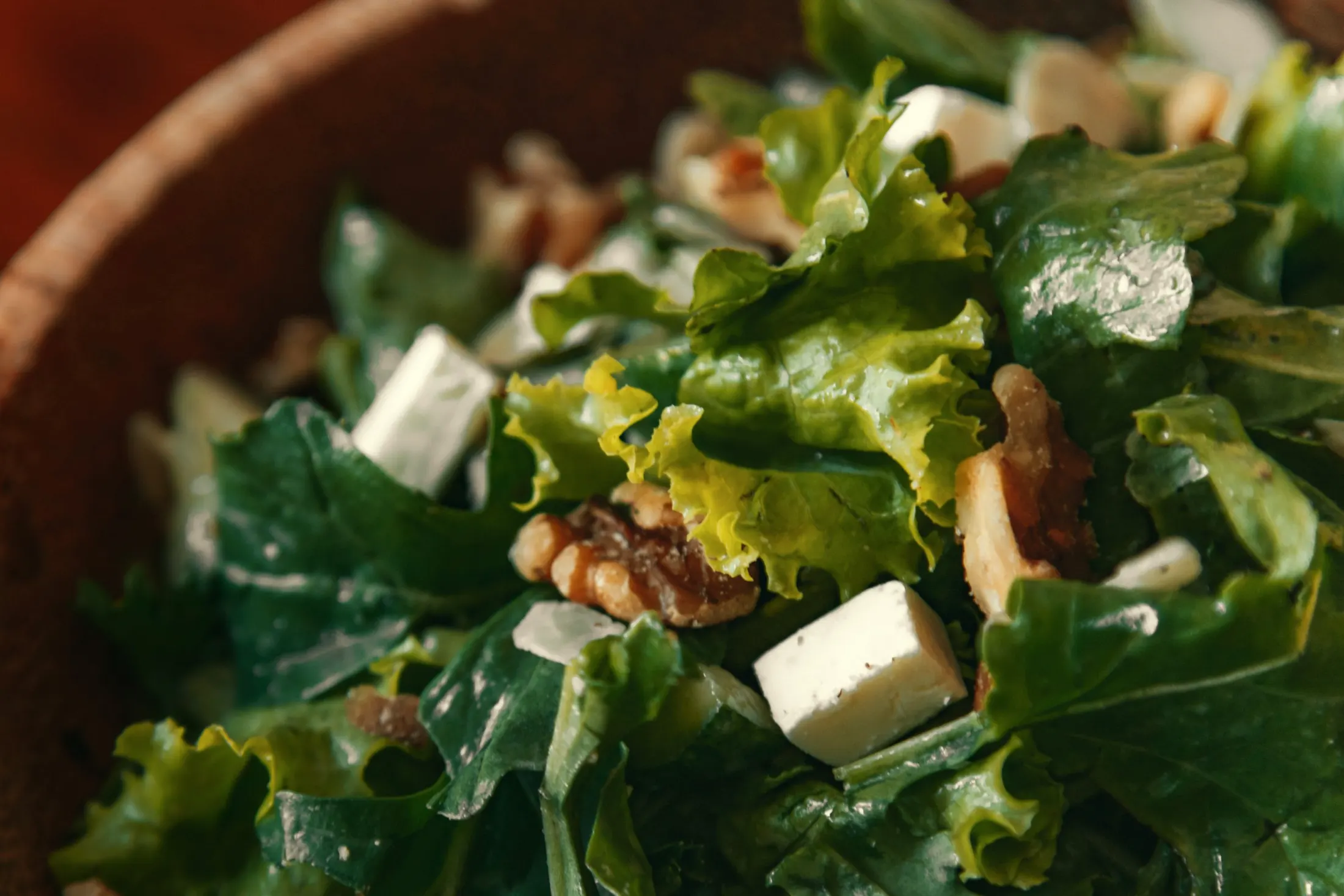 A salad of crisp greens with walnuts and crumbled white cheese